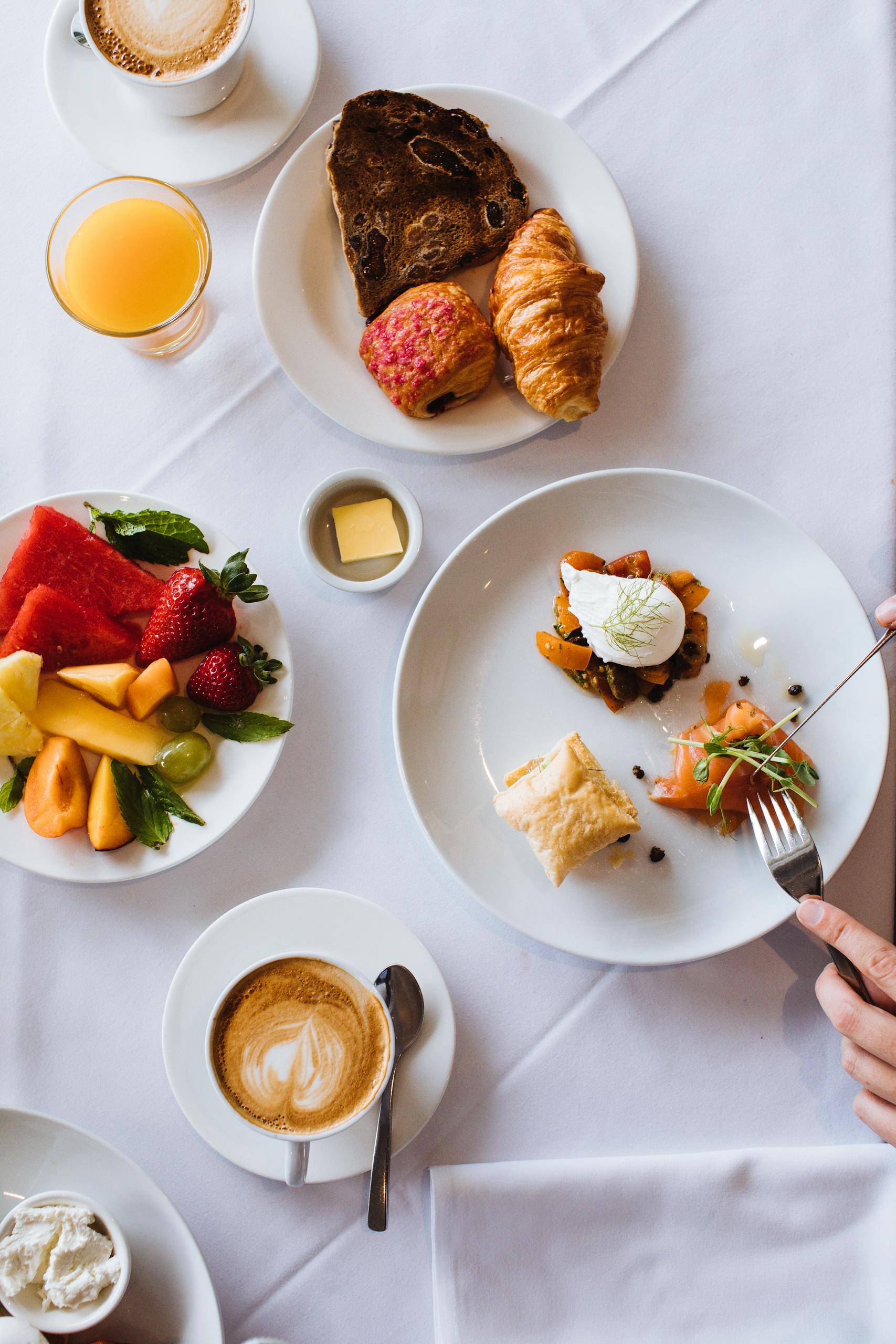 A stylish breakfast setup featuring croissants, fresh fruit, and coffee, ideal for food lovers.