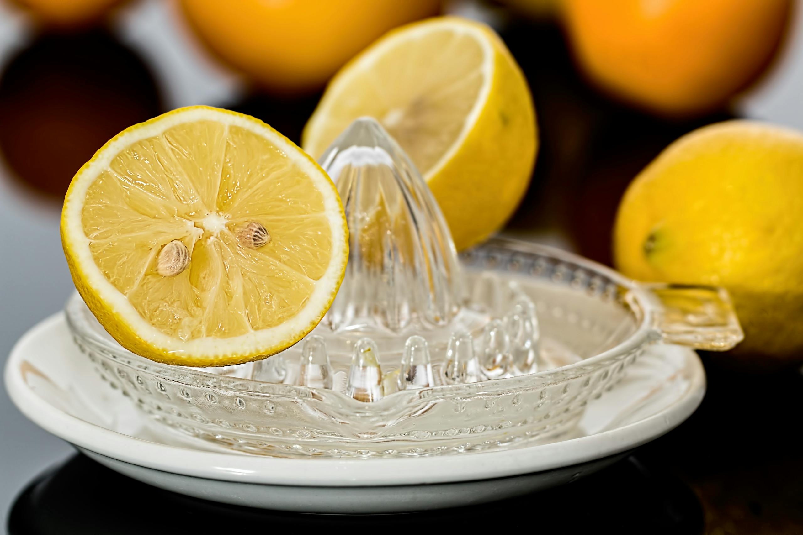 Close-up of fresh lemons on a glass juicer ready to make citrus refreshment.