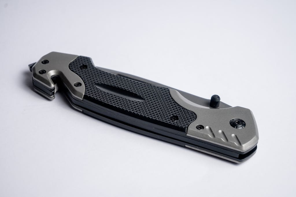 High-quality image of a folding knife with a sleek metallic finish on a white background.