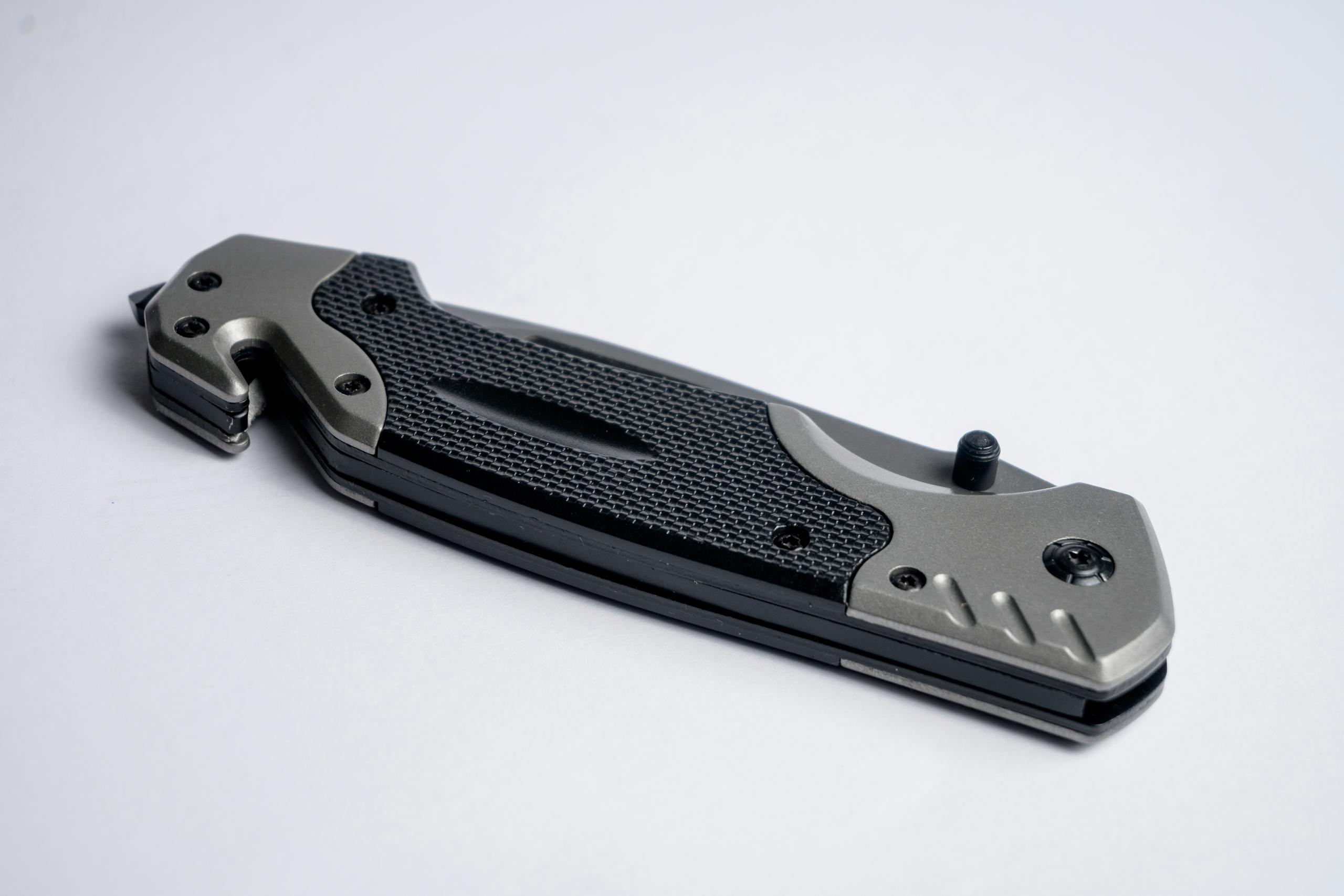 High-quality image of a folding knife with a sleek metallic finish on a white background.