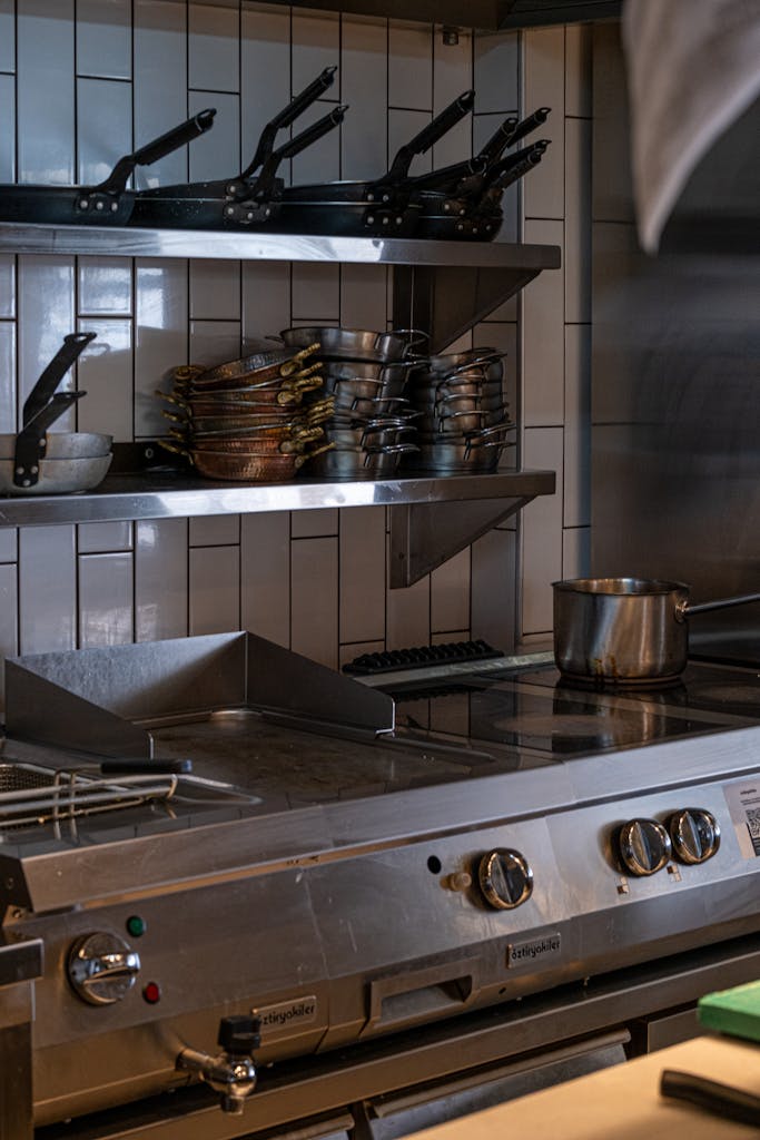 Industrial kitchen setup with stainless steel appliances, pots, and pans.